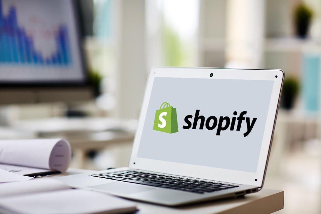 Picture of shopify logo with word "shopify" to the right of it on a laptop